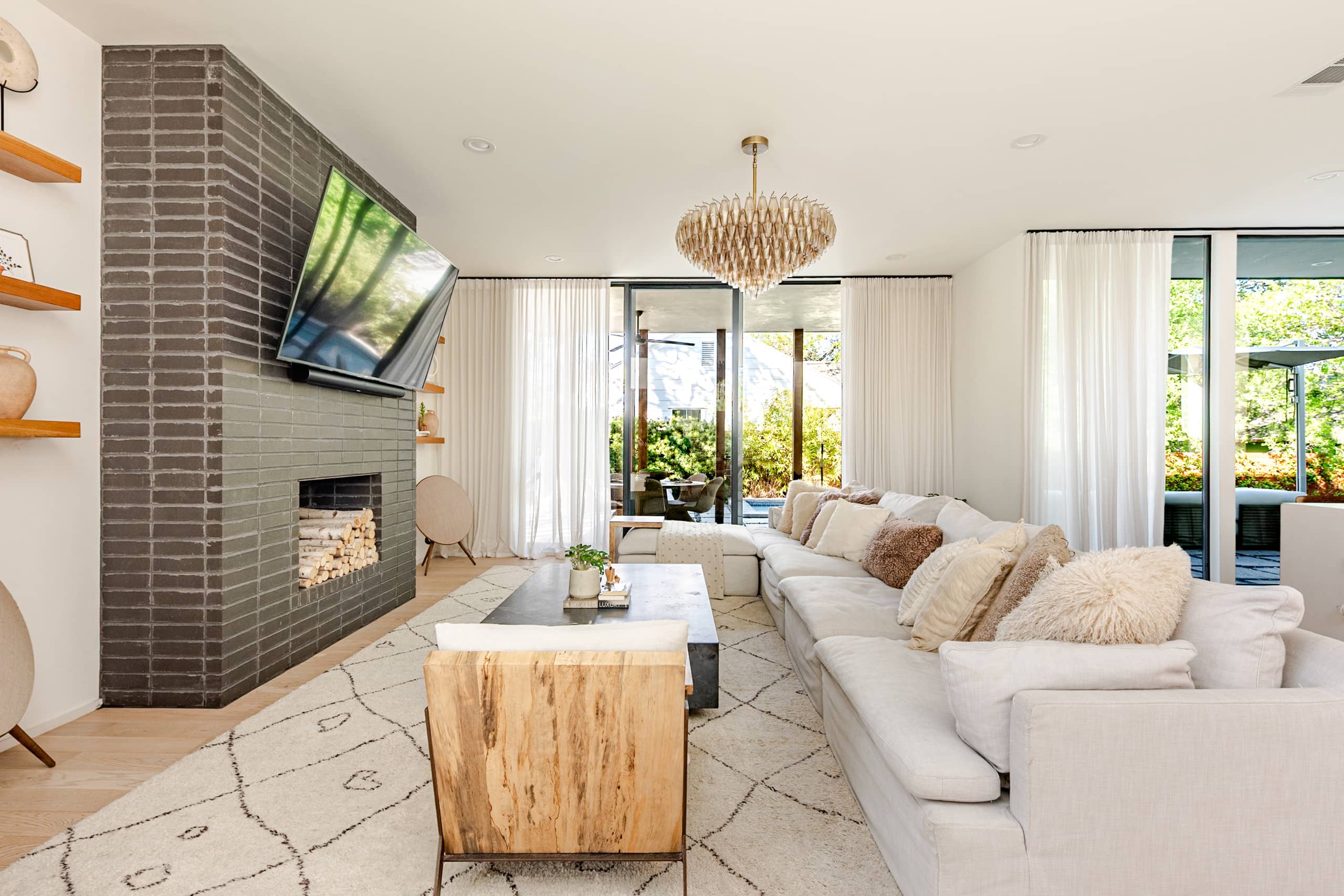 Living room of Bali in Bouldin, a Véla-designed short-term rental in Austin's 78704 — layered natural materials in warm golden-hour light